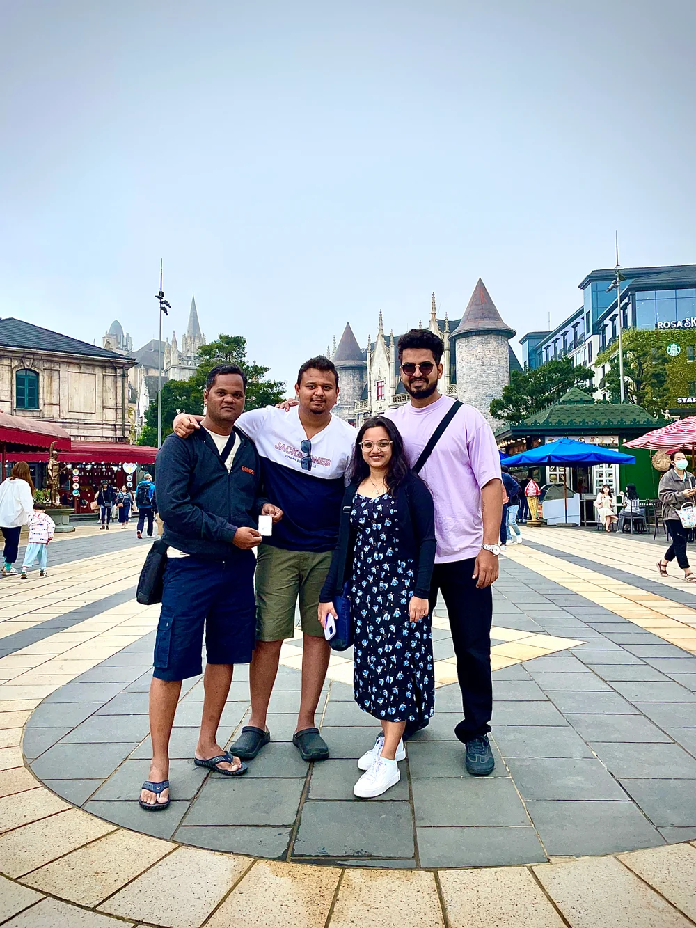 A group of four posing together in a town square